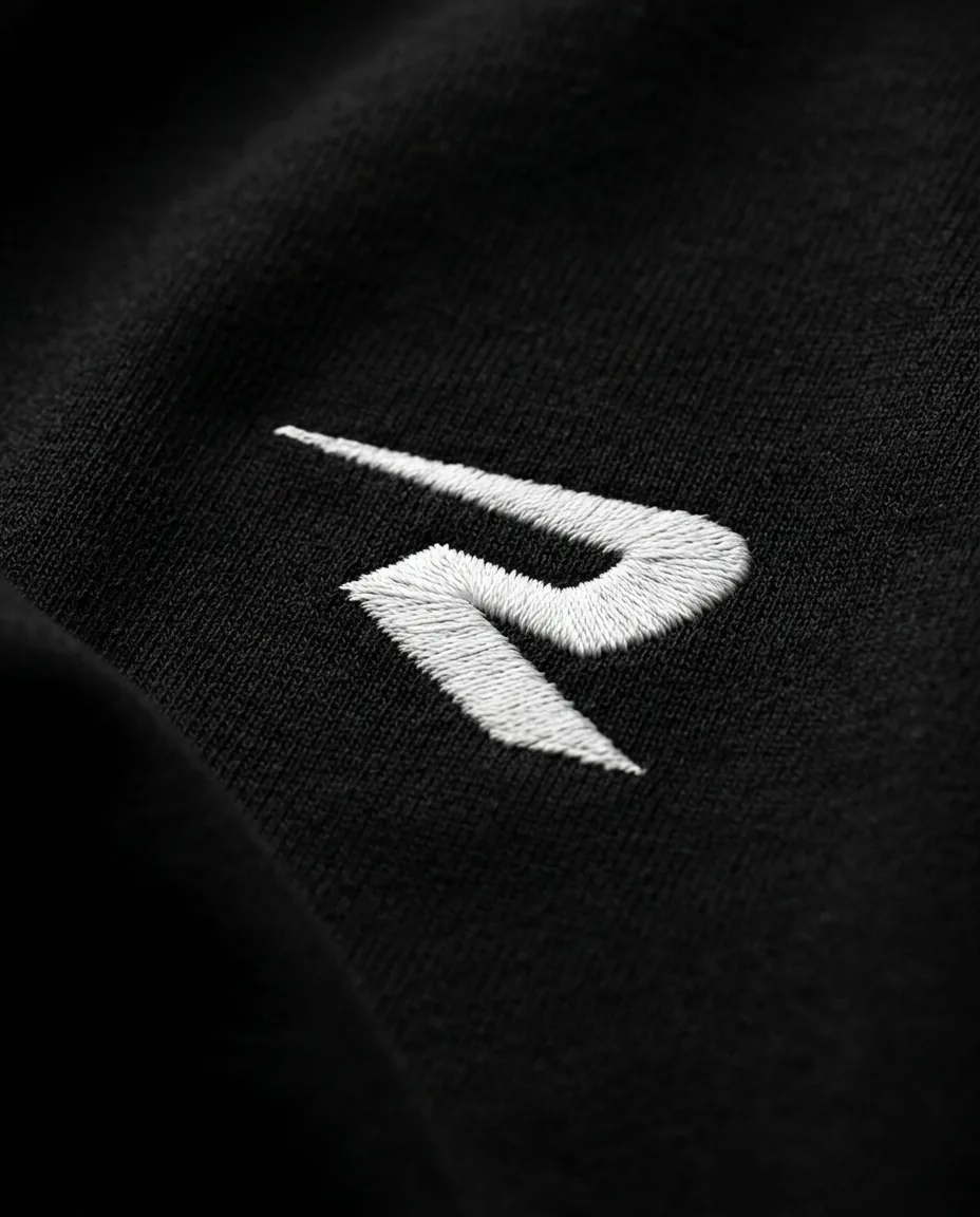 Le R brodé en fil blanc sur un jersey épais